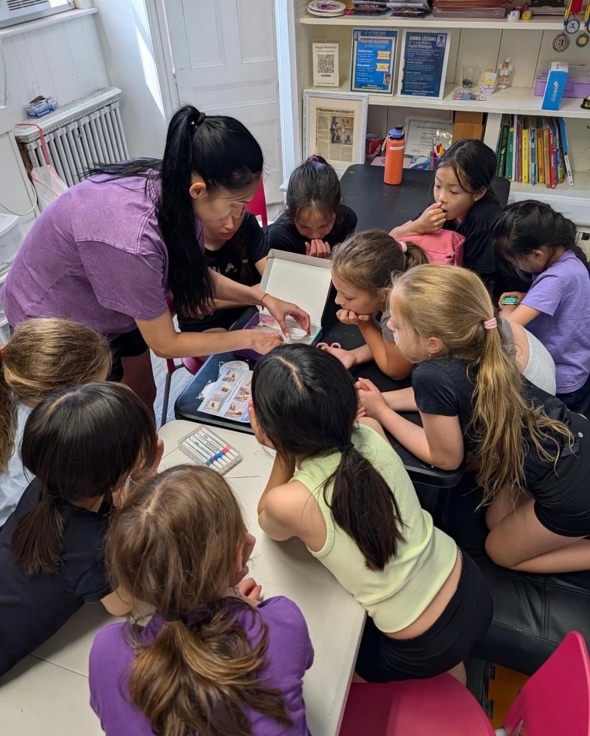 Coach showing a craft project to a group of campers