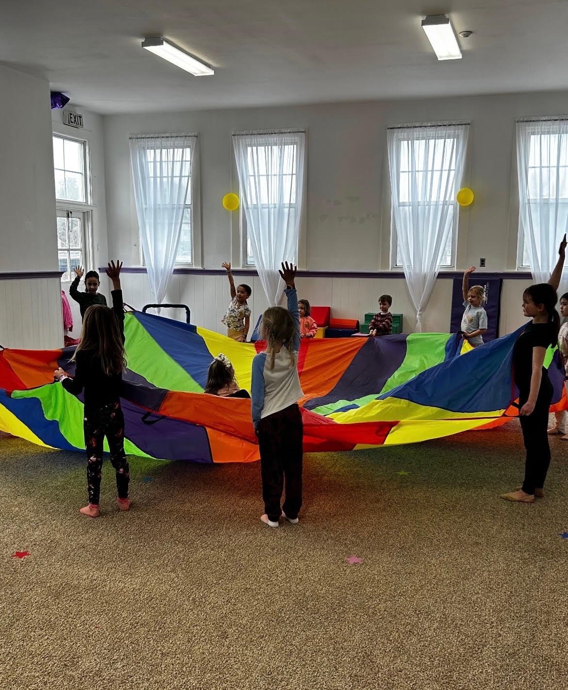 Children playing a parachute game in the Level Up gym